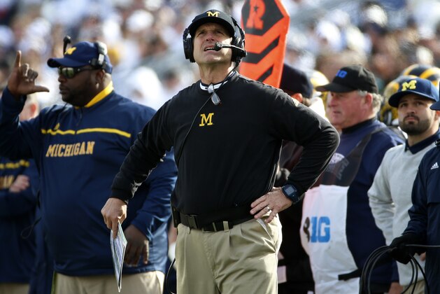Michigan head coach Jim Harbaugh looks at a scoreboard replay from the sidelines during the second half of an NCAA college football game against Penn State in State College, Pa., Saturday, Nov. 21, 2015. Michigan won 28-16. (AP Photo/Gene J. Puskar)