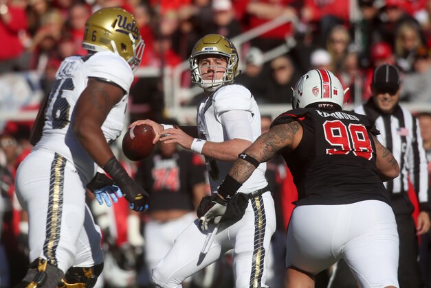 UCLA quarterback Josh Rosen, middle, drops back for a pass as Utah defensive tackle Viliseni Fauonuku (98) goes in for a tackle in the first half of an NCAA college football game on Saturday, Nov. 21, 2015 in Salt Lake City. (AP Photo/Kim Raff)