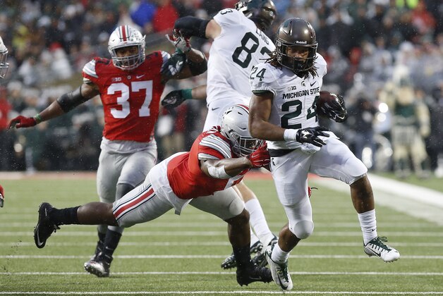 Nov 21, 2015; Columbus, OH, USA; Michigan State Spartans running back Gerald Holmes (24) carries the ball as Ohio State Buckeyes linebacker Raekwon McMillan (5) attempts the tackle in the second quarter at Ohio Stadium. Mandatory Credit: Geoff Burke-USA TODAY Sports Nov 21, 2015; Columbus, OH, USA; Michigan State Spartans running back Gerald Holmes (24) carries the ball as Ohio State Buckeyes linebacker Raekwon McMillan (5) attempts the tackle in the second quarter at Ohio Stadium. Mandatory Credit: Geoff Burke-USA TODAY Sports