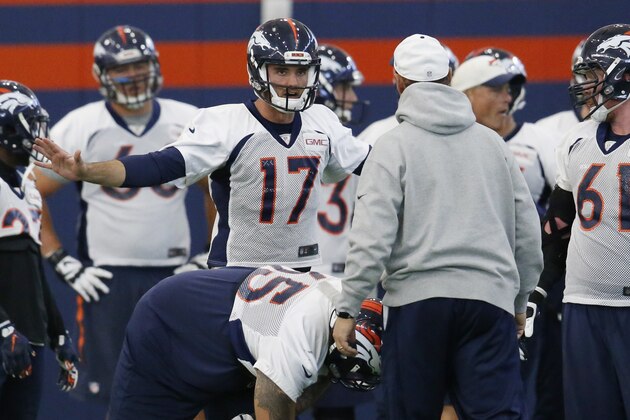 Denver Broncos quarterback Brock Osweiler, back, talks to offensive coordinator Rick Dennison, front, during a practice session at the team's headquarters Wednesday, Nov. 18, 2015, in Englewood, Colo. (AP Photo/David Zalubowski)
