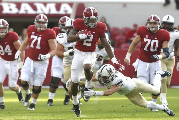 Alabama running back Derrick Henry (2) carries the ball for a first down as he is tripped up by Charleston Southern linebacker Zack Johnson (22) during the first half of an NCAA football game, Saturday, Nov. 21, 2015, in Tuscaloosa, Ala. (AP Photo/Butch Dill)