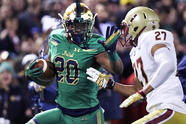 Notre Dame running back C.J. Prosise (20) tries to elude Boston College defensive back Justin Simmons (27) on a drive during the first half of the Shamrock Series NCAA college football game at Fenway Park, home of the Boston Red Sox, in Boston, Saturday, Nov. 21, 2015. (AP Photo/Charles Krupa)