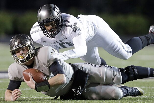Vanderbilt quarterback Kyle Shurmur (14) is brought down by Texas A&M defensive lineman Daeshon Hall in the first half of an NCAA college football game Saturday, Nov. 21, 2015, in Nashville, Tenn. (AP Photo/Mark Humphrey)