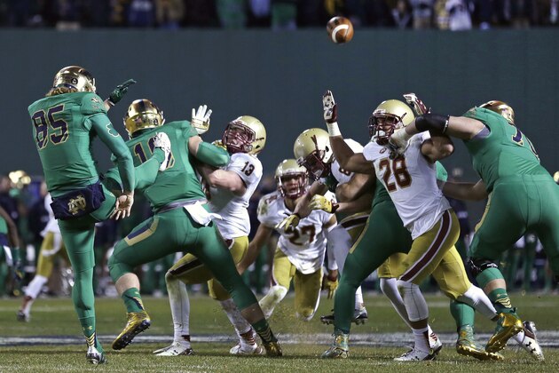 Boston College players try to block a kick by Notre Dame punter Tyler Newsome (85) during the fourth quarter of the Shamrock Series NCAA college football game at Fenway Park, home of the Boston Red Sox, in Boston Saturday, Nov. 21, 2015. Notre Dame won 19-16. (AP Photo/Charles Krupa)