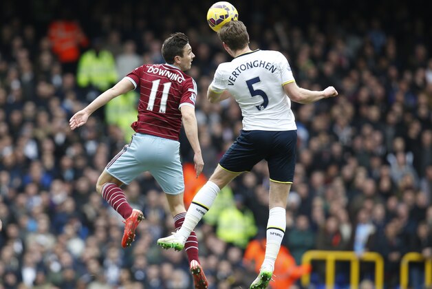 Tottenham Hotspur's Jan Vertonghen, right, jumps for the ball with West Ham United's Stewart Downing, left, during an English Premier League soccer match at the White Hart Lane ground in London, Sunday, Feb. 22, 2015.  The match ended 2-2 draw. (AP Photo/Lefteris Pitarakis)