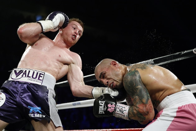 Miguel Cotto, right, of Puerto Rico, and Canelo Alvarez, of Mexico, fight each other during a WBC middleweight title bout Saturday, Nov. 21, 2015, in Las Vegas. (AP Photo/John Locher)