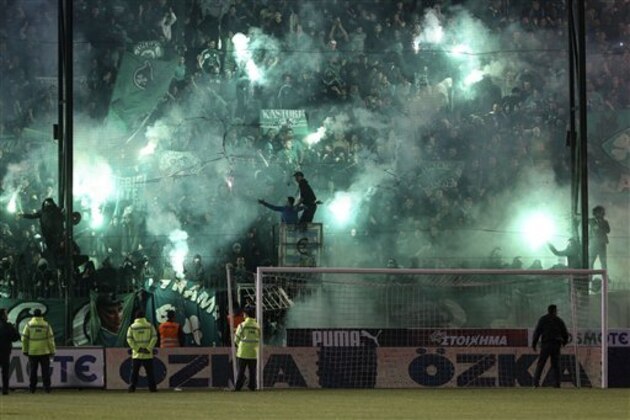 CORRECTS YEAR - Panathinaikos fans light flares after the cancellation of the Greek Super League match between Panathinaikos and Olympiakos at Apostolos Nikolaides stadium in Athens, Saturday, Nov. 21, 2015. The derby between host Panathinaikos and archrival Olympiakos, the Greek league’s frontrunner, has been cancelled after Panathinaikos fans clashed with police both outside and inside the football ground before the game and also threw flares at Olympiakos players when the latter entered the field. (AP Photo/Yorgos Karahalis)
