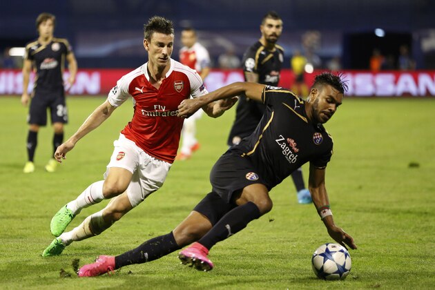 Zagreb's El Arabi Hilal Soudani, right, steers the ball away from Arsenal's Laurent Koscielny during a Champions League Group F soccer match between Dinamo Zagreb and Arsenal at the Maksimir Stadium in Zagreb, Croatia, Wednesday Sept. 16, 2015. (AP Photo/Darko Bandic)