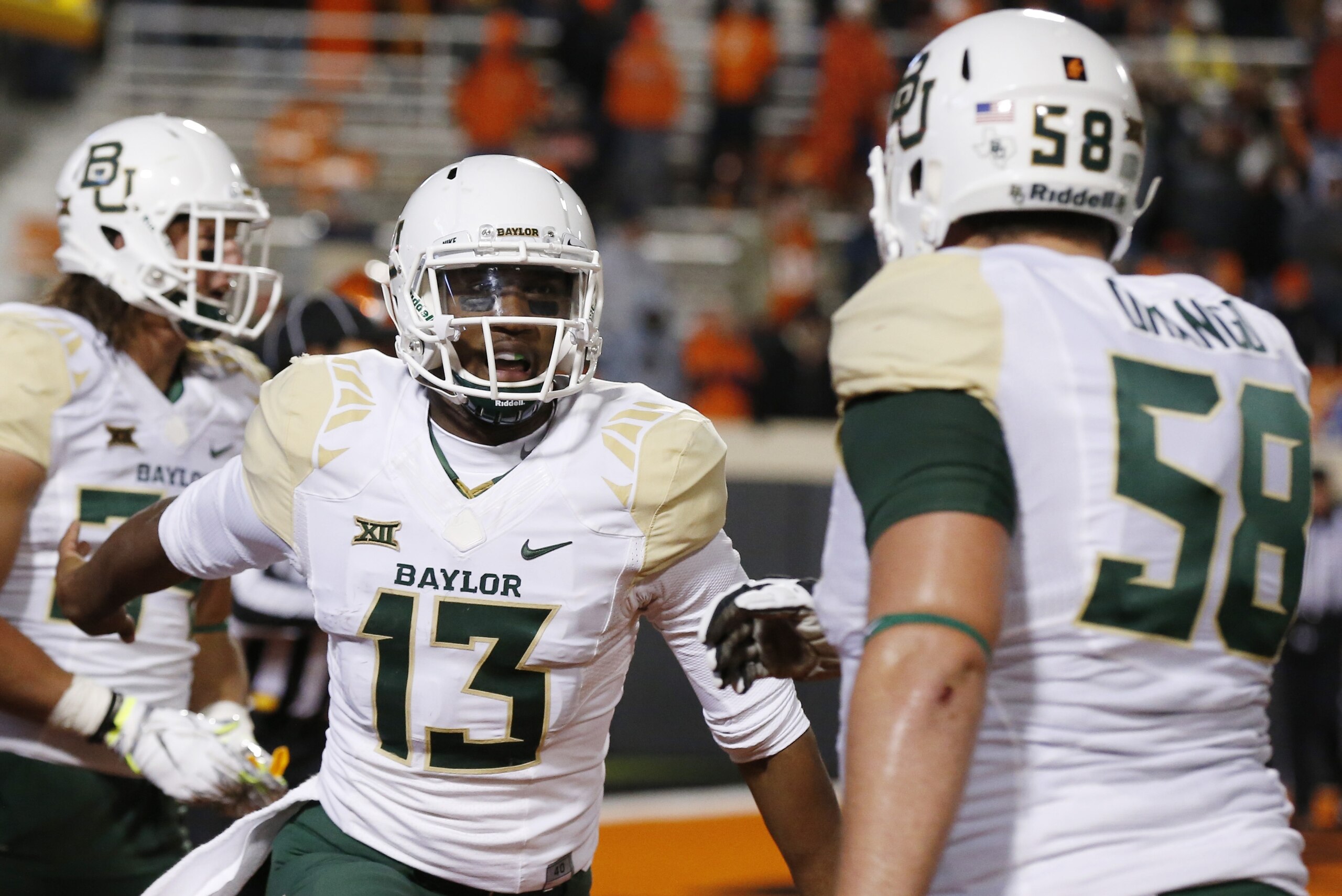 Baylor quarterback Chris Johnson (13) celebrates a touchdown with teammate Spencer Drango (58) during the fourth quarter of an NCAA college football game against Oklahoma State in Stillwater, Okla., Saturday, Nov. 21, 2015. Baylor won 45-35. (AP Photo/Sue Ogrocki)