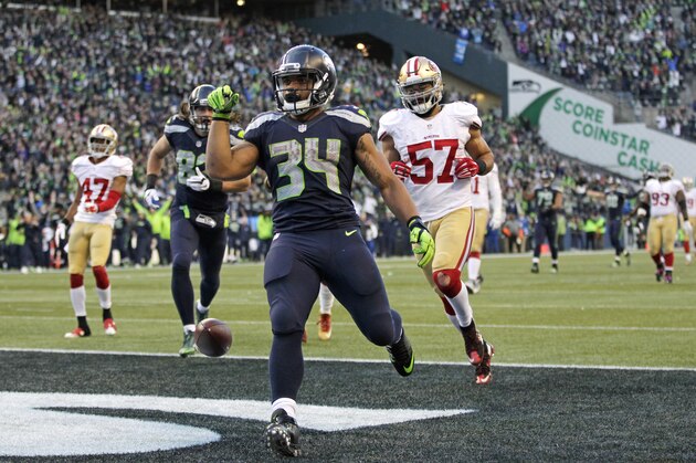 Seattle Seahawks running back Thomas Rawls (34) drops the ball after scoring a touchdown ahead of San Francisco 49ers inside linebacker Michael Wilhoite (57) during the second half of an NFL football game Sunday, Nov. 22, 2015, in Seattle. (AP Photo/John Froschauer)