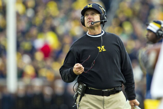 Michigan head coach Jim Harbaugh, wearing a headset, looks up at the scoreboard from the sideline in the third quarter of an NCAA college football game against Michigan State in Ann Arbor, Mich., Saturday, Oct. 17, 2015. Michigan State won 27-23. (AP Photo/Tony Ding)
