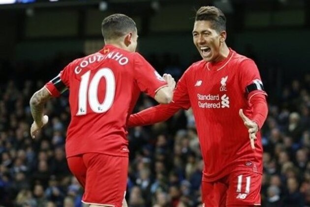 Liverpool’s Roberto Firmino celebrates with teammate Liverpool’s Philippe Coutinho after his cross which is then turned in by Manchester City's Eliaquim Mangala who scores an own goal for the opening goal of the game during the English Premier League soccer match between Manchester City and Liverpool at the Etihad Stadium, Manchester, England, Saturday, Nov. 21, 2015. (AP Photo/Jon Super)