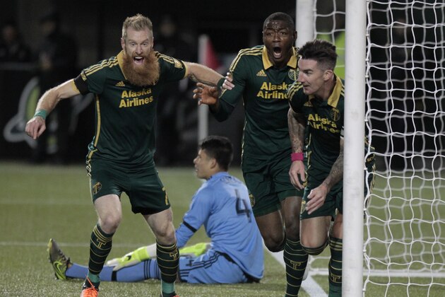 Portland Timbers defender Nat Borchers (7) forward Fanendo Adi and defender Liam Ridgewell, right, celebrate Ridgewell's goal during the first half of the first leg of the MLS soccer Western Conference championship against FC Dallas in Portland, Ore., Sunday, Nov. 22, 2015. (AP Photo/Steve Dipaola)