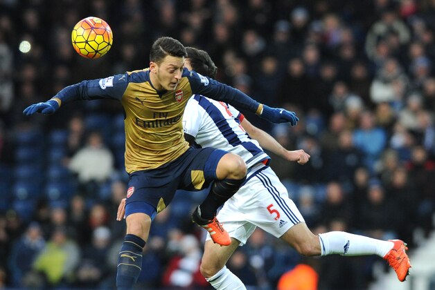 Arsenal’s Mesut Ozil, left, and West Brom’s Claudio Yacob battle for the ball during the English Premier League soccer match between West Bromwich Albion and Arsenal at the Hawthorns, West Bromwich, England, Saturday, Nov. 21, 2015. (AP Photo/Rui Vieira)