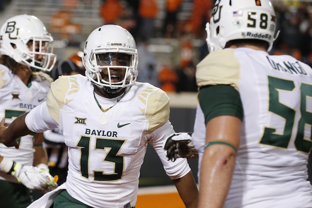 Baylor quarterback Chris Johnson (13) celebrates a touchdown with teammate Spencer Drango (58) during the fourth quarter of an NCAA college football game against Oklahoma State in Stillwater, Okla., Saturday, Nov. 21, 2015. Baylor won 45-35. (AP Photo/Sue Ogrocki)