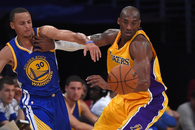 Golden State Warriors guard Stephen Curry, left, and Los Angeles Lakers guard Kobe Bryant battle for a loose ball during the first half of a preseason basketball game, Thursday, Oct. 9, 2014, in Los Angeles.  (AP Photo/Mark J. Terrill)