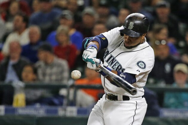 Seattle Mariners' Robinson Cano hits a sacrifice fly to score Kyle Seager in the first inning of a baseball game against the Houston Astros, Tuesday, Sept. 29, 2015, in Seattle. (AP Photo/Ted S. Warren)