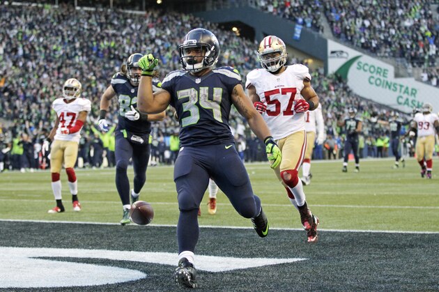 Seattle Seahawks running back Thomas Rawls (34) scores a touchdown ahead of San Francisco 49ers inside linebacker Michael Wilhoite (57) in the second half of an NFL football game, Sunday, Nov. 22, 2015, in Seattle. (AP Photo/John Froschauer)