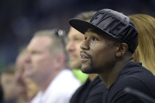 Boxer Floyd Mayweather Jr., right, watches from court side seats during the first half of an NBA basketball game between the Orlando Magic and the Oklahoma City Thunder in Orlando, Fla., Friday, Oct. 30, 2015. (AP Photo/Phelan M. Ebenhack)