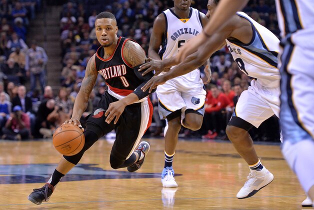 Portland Trail Blazers guard Damian Lillard (0) drives past Memphis Grizzlies forwards Zach Randolph, center, and Tony Allen (9) in the second half of an NBA basketball game Friday, Nov. 13, 2015, in Memphis, Tenn. (AP Photo/Brandon Dill)