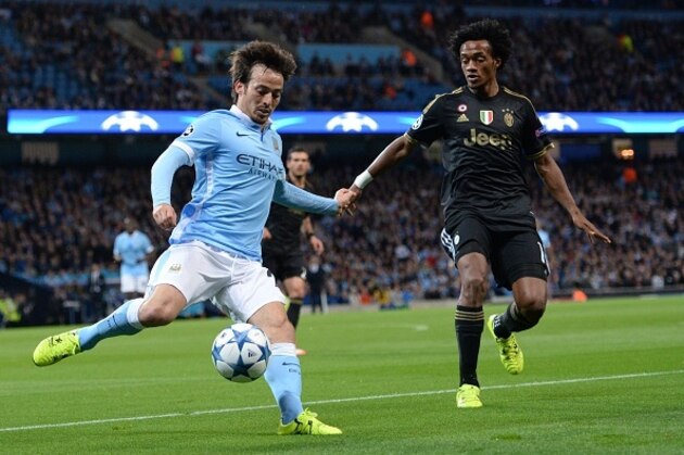 Juventus' forward from Coombia Juan Cuadrado (R) tries to tackle Manchester City's Spanish midfielder David Silva during a UEFA Champions League group stage football match between Manchester City and Juventus at the Etihad stadium in Manchester, north-west England on September 15, 2015.    AFP PHOTO / OLI SCARFF        (Photo credit should read OLI SCARFF/AFP/Getty Images)