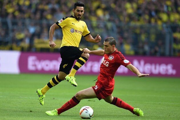 Dortmund's midfielder Ilkay Guendogan (L) and Leverkusen's Greek defender Kyriakos Papadopoulos vie for the ball during the German first division Bundesliga football match Borussia Dortmund vs Bayer Leverkusen in Dortmund, western Germany on September 20, 2015.  AFP PHOTO / PATRIK STOLLARZ

RESTRICTIONS: DURING MATCH TIME: DFL RULES TO LIMIT THE ONLINE USAGE TO 15 PICTURES PER MATCH AND FORBID IMAGE SEQUENCES TO SIMULATE VIDEO. 
== RESTRICTED TO EDITORIAL USE ==  FOR FURTHER QUERIES PLEASE CONTACT DFL DIRECTLY AT + 49 69 650050.        (Photo credit should read PATRIK STOLLARZ/AFP/Getty Images)