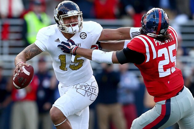 OXFORD, MS - NOVEMBER 29:  Cody Prewitt #25 of the Mississippi Rebels tries to tackle Dak Prescott #15 of the Mississippi State Bulldogs during their game at Vaught-Hemingway Stadium on November 29, 2014 in Oxford, Mississippi.  (Photo by Streeter Lecka/Getty Images)
