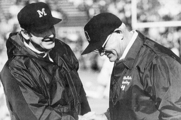 Michigan football coach Bo Schembechler, left, meets with Ohio State coach Woody Hayes in this undated photo, location unknown. There's a sign in the Ohio State locker room that says,