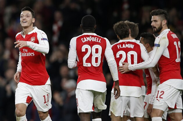 Arsenal's German midfielder Mesut Ozil (L) celebrates after scoring his team's first goal during their UEFA Champions League Group F football match between Arsenal and GNK Dinamo Zagreb at The Emirates Stadium in London on November 24, 2015. AFP PHOTO / ADRIAN DENNIS / AFP / ADRIAN DENNIS        (Photo credit should read ADRIAN DENNIS/AFP/Getty Images)