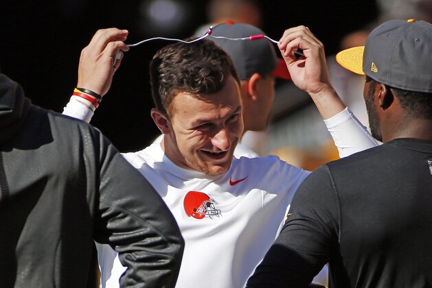 Cleveland Browns quarterback Johnny Manziel, center, visits with Pittsburgh Steelers quarterback Mike Vick (2) before an NFL football game, Sunday, Nov. 15, 2015, in Pittsburgh. (AP Photo/Gene J. Puskar)