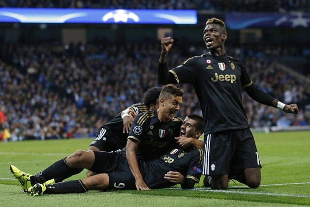 Juventus' Alvaro Morata, centre, celebrates with teammates including Paul Pogba, right, after scoring his sides second goal during the Champions League group D soccer match between Manchester City and Juventus at the Etihad Stadium, Manchester, England, Tuesday, Sept. 15, 2015. (AP Photo/Jon Super)