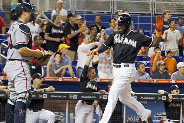 Miami Marlins' Marcell Ozuna runs to score past Atlanta Braves catcher Ryan Lavarnway (30) in the eighth inning during a baseball game in Miami, Saturday, Sept. 26, 2015. Ozuna scored on a single by teammate Casey McGehee during the Marlins' 6-2 win over the Braves. (AP Photo/Joe Skipper)
