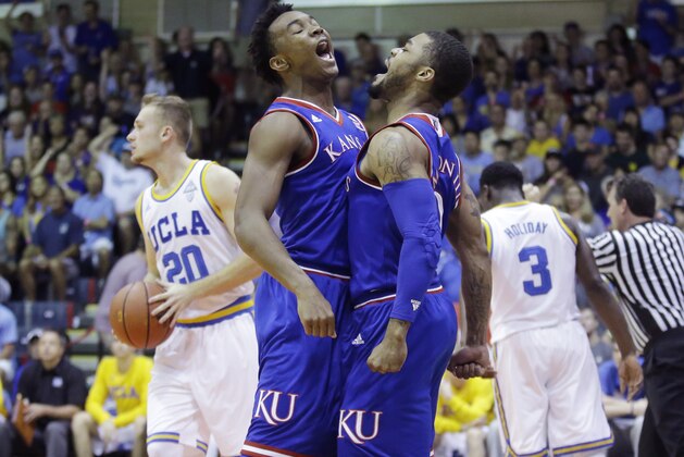 Kansas' Frank Mason III, center right, celebrates with Devonte' Graham, center, left, after scoring, as UCLA's Bryce Alford (20) and Aaron Holiday (3) walk away, in the first half during an NCAA college basketball game in the second round of the Maui Invitational, Tuesday, Nov. 24, 2015, in Lahaina, Hawaii. (AP Photo/Rick Bowmer)
