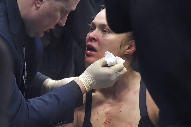 Ronda Rousey is tended to by a medical staff member after being knocked out by Holly Holm in their UFC 193 bantamweight title fight in Melbourne, Australia, Sunday, Nov. 15, 2015. Holm pulled off a stunning upset victory over Rousey in the fight, knocking out the women's bantamweight champion in the second round with a powerful kick to the head Sunday.  (AP Photo/Andy Brownbill)