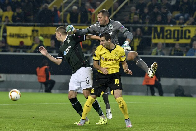Krasnodar's keeper Andriy Dykan, up, Artur Jedrzejczyk, left, and Dortmund's Henrikh Mkhitaryan challenge for the ball during the Europa League group C soccer match between Borussia Dortmund and FC Krasnodar in Dortmund, Germany, Thursday, Sept. 17, 2015. (AP Photo/Martin Meissner)