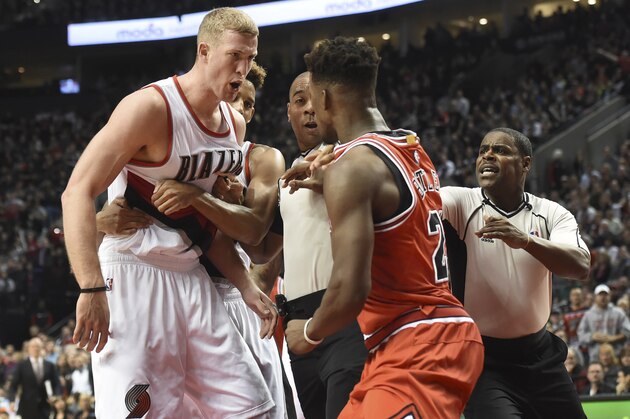Chicago Bulls guard Jimmy Butler, right, and Portland Trail Blazers center Mason Plumlee (24) are separated by the officials after getting into a shoving match during the fourth quarter of an NBA basketball game in Portland, Ore., Tuesday, Nov 24, 2015. The Bulls won 93-88. (AP Photo/Steve Dykes)