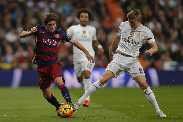 Real Madrid's Toni Kroos, right, duels for the ball with Barcelona's Sergi Roberto during the first clasico of the season between Real Madrid and Barcelona at the Santiago Bernabeu stadium in Madrid, Spain, Saturday, Nov. 21, 2015. (AP Photo/Daniel Ochoa de Olza)