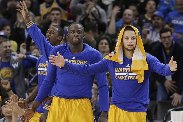 Golden State Warriors guard Stephen Curry, right, celebrates on the bench with forward Draymond Green, center, and forward Harrison Barnes during the second half of an NBA basketball game against the Los Angeles Lakers in Oakland, Calif., Tuesday, Nov. 24, 2015. The Warriors won 111-77. (AP Photo/Jeff Chiu)