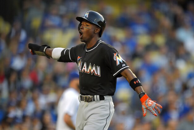 Miami Marlins' Dee Gordon celebrates after scoring on a single by Giancarlo Stanton during the seventh inning of a baseball game against the Los Angeles Dodgers, Wednesday, May 13, 2015, in Los Angeles. (AP Photo/Mark J. Terrill)