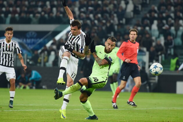 TURIN, ITALY - NOVEMBER 25:  Mario Mandzukic of Juventus directs a shot on goal past the challenge from Nicolas Otamendi of Manchester City during the UEFA Champions League group D match between Juventus and Manchester City FC at the Juventus Stadium on November 25, 2015 in Turin, Italy.  (Photo by Mike Hewitt/Getty Images)