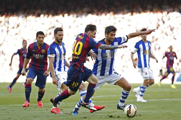 FC Barcelona's Lionel Messi, second right, duels for the ball against Real Sociedad's Markel Bergara, right, during a Spanish La Liga soccer match at the Camp Nou stadium in Barcelona, Spain, Saturday, May 9, 2015. (AP Photo/Manu Fernandez)