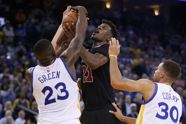 Chicago Bulls guard Jimmy Butler (21) is fouled by Golden State Warriors forward Draymond Green (23) as Stephen Curry, right, looks on during the second half of an NBA basketball game Friday, Nov. 20, 2015, in Oakland, Calif. Warriors won 106-94. (AP Photo/Tony Avelar)
