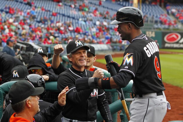 Miami Marlins' Dee Gordon (9) is congratulated in the dugout by teammates after scoring on a double by Justin Bour in the first inning against the Philadelphia Phillies during a baseball game Sunday, Oct. 4, 2015, in Philadelphia. (AP Photo/Rich Schultz)