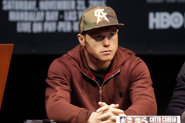 Two time world champion, Saul 'Canelo' Alvarez from Guadalajara, Mexico looks on as former WBC Middleweight World Champion Miguel Cotto, from Puerto Rico speaks during a press conference in Las Vegas, Nevada on November 18, 2015.  Cotto was stripped of his World Boxing Council middleweight world title on Tuesday, days before his anticipated bout against Mexican Saul Alvarez in Las Vegas on Saturday. Amid reports that Cotto declined to pay the USD 300,000 sanctioning fee for a title fight, the WBC said in a statement only that the Puerto Rican and his camp failed to comply with WBC regulations. AFP PHOTO/ John Gurzinski        (Photo credit should read JOHN GURZINSKI/AFP/Getty Images)