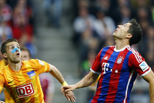 Berlin's Peter Pekarik from Slovakia, left, and Bayern's Robert Lewandowski from Poland challenge for the ball during the German first division Bundesliga soccer match between FC Bayern Munich and Hertha BSC at the Allianz Arena in Munich, Germany, on Saturday, April 25, 2015. (AP Photo/Matthias Schrader)