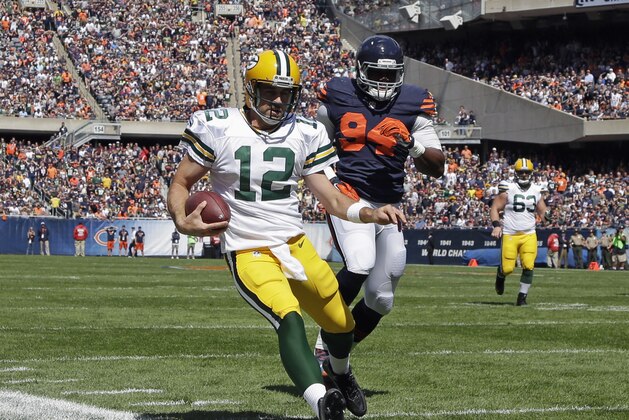 Aaron Rodgers, quarterback de los Packers de Green Bay, elude al defensive end Cornelius Washington, de los Bears de Chicago, durante la primera mitad del encuentro disputado el domingo 13 de septiembre de 2015 (AP Foto/Nam Y. Huh)