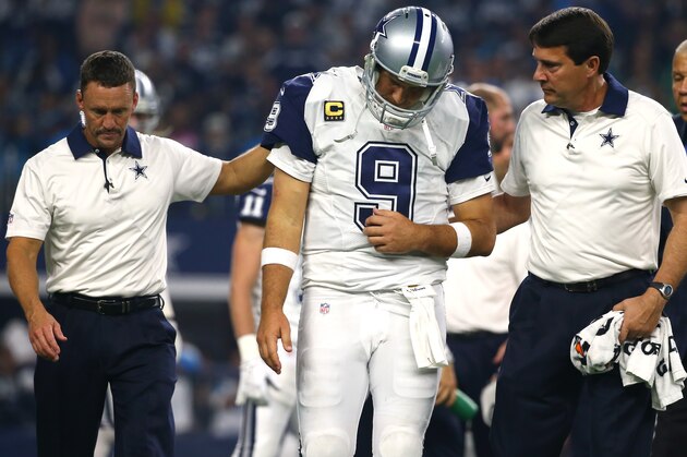 ARLINGTON, TX - NOVEMBER 26: Tony Romo #9 of the Dallas Cowboys is lead to the sidelines by team officials after being sacked by the Carolina Panthers in the third quarter at AT&T Stadium on November 26, 2015 in Arlington, Texas. Romo left the field following the play. (Photo by Tom Pennington/Getty Images) ARLINGTON, TX - NOVEMBER 26: Tony Romo #9 of the Dallas Cowboys is lead to the sidelines by team officials after being sacked by the Carolina Panthers in the third quarter at AT&T Stadium on November 26, 2015 in Arlington, Texas. Romo left the field following the play. (Photo by Tom Pennington/Getty Images)
