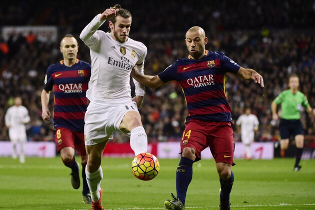 Real Madrid's Welsh forward Gareth Bale  (L) vies with Barcelona's Argentinian defender Javier Mascherano during the Spanish league 'Clasico' football match Real Madrid CF vs FC Barcelona at the Santiago Bernabeu stadium in Madrid on November 21, 2014.   AFP PHOTO / PIERRE-PHILIPPE MARCOU        (Photo credit should read PIERRE-PHILIPPE MARCOU/AFP/Getty Images)