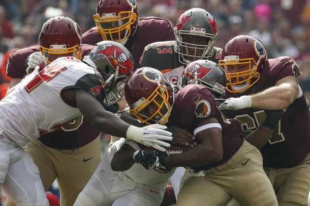 ADVANCE FOR SUNDAY, NOV. 1 AND THEREAFTER - In this photo taken Oct. 25, 2015, Washington Redskins running back Alfred Morris (46) is stopped by the Tampa Bay Buccaneers defense during the first half of an NFL football game in Landover, Md. In their actions and their words at the outset of this season, new general manager and second-year head coach Jay Gruden made quite clear that they wanted the Washington Redskins to be a run-first team. And they did, indeed, begin things that way, becoming the first NFL club in nearly a decade to have a pair of guys each rush for 100 yards in Weeks 1 and 2.(AP Photo/Alex Brandon)