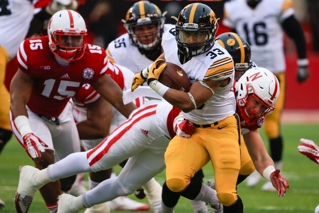 Iowa running back Jordan Canzeri (33) breaks a tackle by Nebraska linebacker Chris Weber (49) during the first half of an NCAA college football game in Lincoln, Neb., Friday, Nov. 27, 2015. (AP Photo/Nati Harnik)